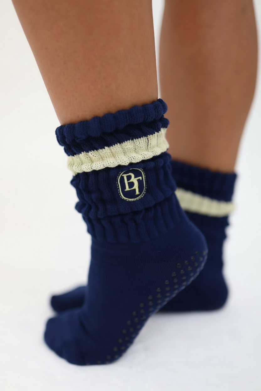 Navy blue socks with a baby yellow stripe and logo on a white background