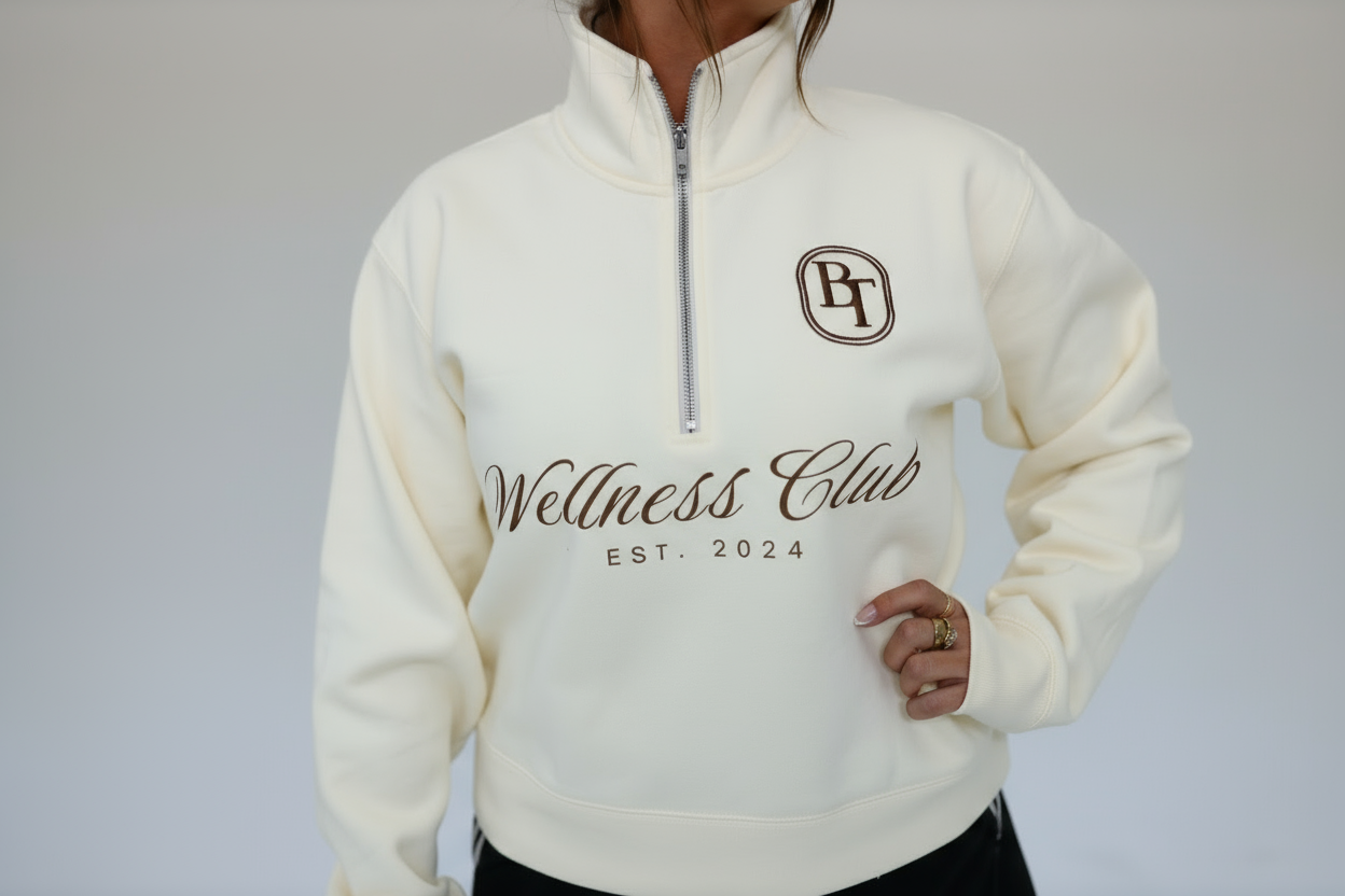 White sweatshirt with 'Wellness Club EST. 2024' text and logo on a plain background